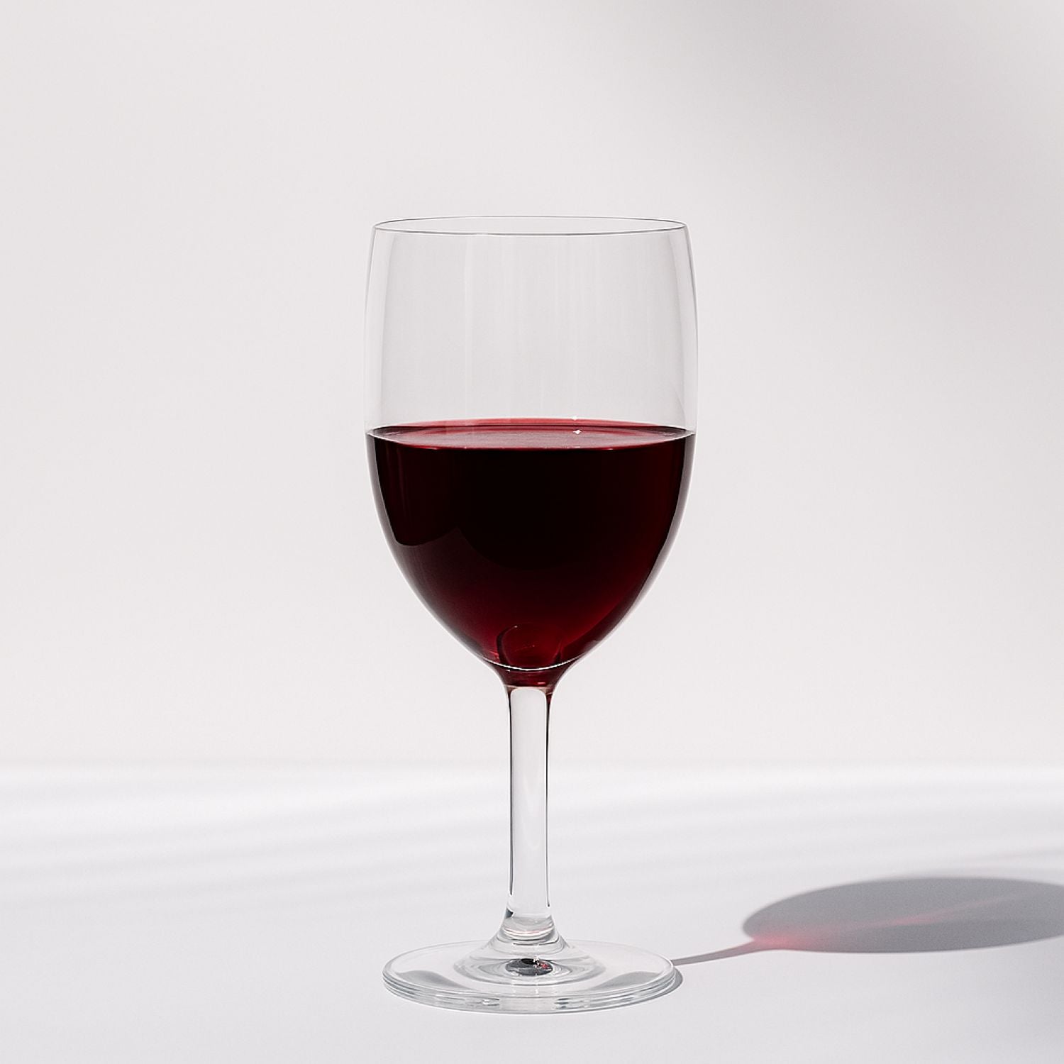 Laurant wine glass filled with red wine on a clean studio background